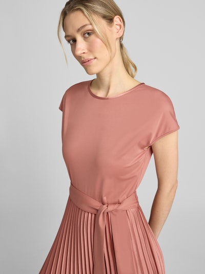Vrouwenmodel draagt regular fit vrijetijdsjurk met plissés model 'GELA' van Weekend Max Mara in oudroze, nahaufnahme bovenlichaam.