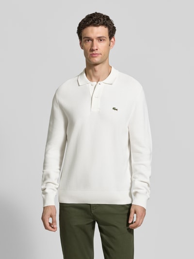 Männermodel trägt Regular Fit Poloshirt aus reiner Baumwolle von Lacoste in Weiß, glatte Oberfläche, Ganzkörperansicht von vorne, Herren Poloshirt von Lacoste