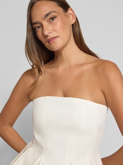 Frauenmodel trägt Bluse mit Leinen-Anteil und Schößchen Modell 'riava' von Gestuz im Lyocell-Mix, Bandeau, Nahaufnahme Oberkörper.
