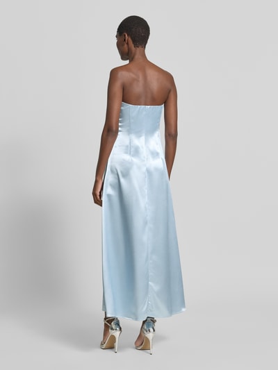Frauenmodel trägt Cocktailkleid in Bandeau-Form Modell 'ORCHIDA' von YAS aus hellblauem Satin, A-Linie, Maxikleid, Ganzkörperansicht Rückansicht.