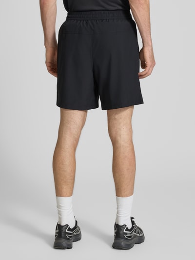 Mannelijk model draagt Shorts met Logo-Print en steekzakken van NIKE TRAINING, recht model, elastische band met trekkoord, kleur zwart, binnenbeenlengte 19 cm, bandwijdte maat M 41 cm, logoprint, zij-steekzakken, geheel effen, ganzkörperansicht rückansicht.