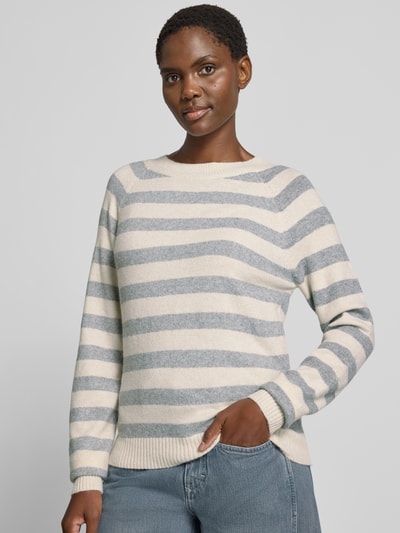 Frauenmodel trägt Regular Fit Pullover mit Streifen Modell 'DOFFY' von VERO MODA in Creme und Hellgrau, grob gestrickt, Nahaufnahme Oberkörper.