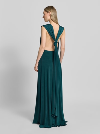 Frauenmodel trägt Maxikleid mit tiefem V-Ausschnitt von Rose Avenue in dunklem Grün, Taillierter Schnitt, Taillenband, Rückseite gekreuzte Träger, Rückenlänge bei Größe S 135 cm, Ganzkörperansicht Rückansicht.