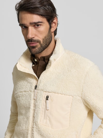 Męski model nosi Sweatjacke aus Teddyfell od Polo Ralph Lauren, kremowa, bawełniana, regular fit, z zamkami; zbliżenie na górę ciała.