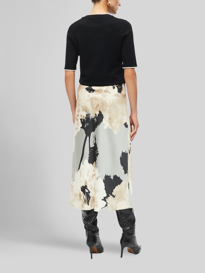 Frauenmodel trägt ausgestellter Midi-Rock aus Viskkose-Mix von s.Oliver BLACK LABEL mit Schwarz-Beige-Print, Ganzkörperansicht Rückansicht.