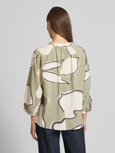 Modelka nosi Bluzkę z okrągłym dekoltem model 'Faloom' od OPUS, miks modalu, krój loose fit, zielono-beżowy wzór, długość tyłu 63 cm, rękaw 3/4, długość rękawa 45 cm, widok całej sylwetki z tyłu.
