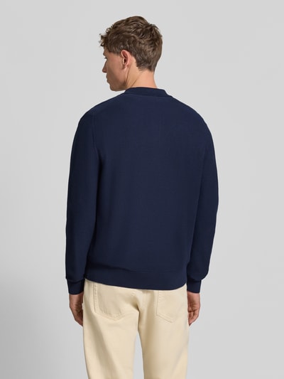Männermodel trägt Regular Fit Poloshirt aus reiner Baumwolle von Lacoste in Dunkelblau, weiche Struktur, Ganzkörperansicht Rückansicht, Herren Poloshirt von Lacoste.