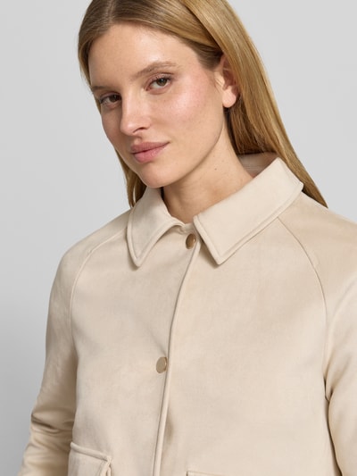Vrouwenmodel draagt Jacke mit Umlegekragen und Pattentaschen van Fuchs Schmitt in lichtbeige, regular fit, materiaal-mix met viscose, knoopsluiting en klepzakken, detailopname bovenlichaam.