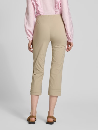 Frauenmodel trägt Caprihose aus Viskose-Mix Modell 'Ina' von STEHMANN in Beige mit Drapierungen, Slim Fit, weiche Textur, Ganzkörperansicht Rückansicht.