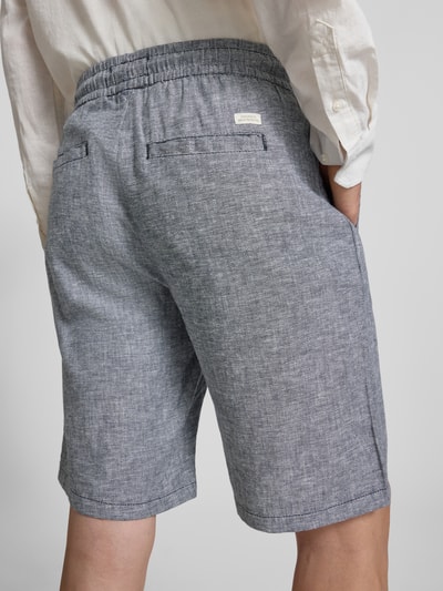 Männermodel trägt Shorts aus Leinen-Mix mit Eingrifftaschen Modell 'MARCO' von Blend, meliertes Grau, elastischer Bund, Ganzkörperansicht Rückansicht.
