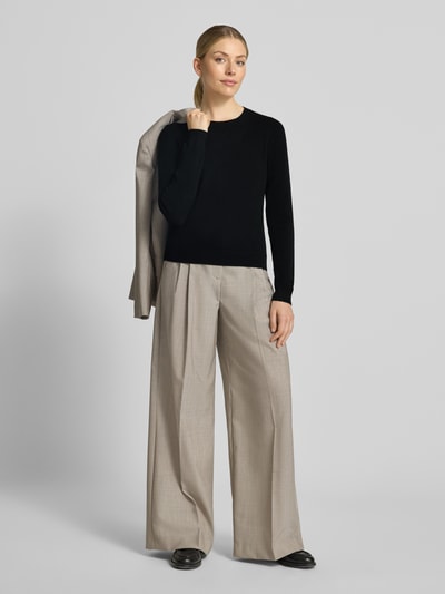 Kobiece modelka nosi Slim Fit Strickpullover aus reinem Kaschmir von Christian Berg Woman, czarny, krój slim fit, kaszmir, elastyczne wykończenia, długość tyłu w rozmiarze S 54 cm, długość rękawów 65 cm, szerokie beżowe spodnie, jasne tło, pełny widok od przodu.