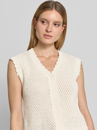 Frauenmodel trägt Strickweste mit V-Ausschnitt Modell 'Maisa' von mbyM, Grobstrick, Baumwoll-Mix, Knopfleiste, Nahaufnahme Oberkörper.
