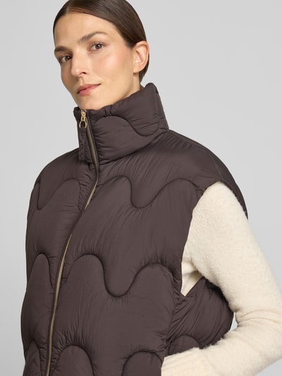 Modelka kobieca ma na sobie Regular Fit Weste mit Stehkragen od Jake*s Casual, kamizelka w kolorze brązowym z pikowaną strukturą, zbliżenie na górną część ciała.