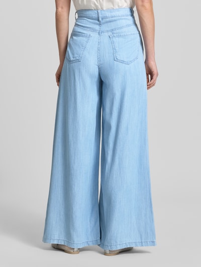 Frauenmodel trägt helle Wide-Fit Jeans aus Lyocell-Mix Modell 'Eva' von Mango mit Eingriff- und Gesäßtaschen, Ganzkörperansicht Rückansicht.