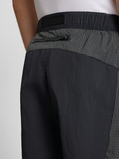 Männermodel trägt Shorts mit Logo und Gürtel von The North Face, Herren Shorts, Regular-Fit, elastischer Bund, Detailaufnahme Rückansicht.