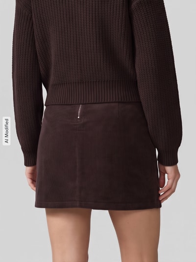 Vrouwenmodel draagt lichaamssluitende minirok uit katoenmix model 'LULA' van VERO MODA in donkerbruin, volledig van achteren, KI-modificeerd beeld