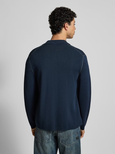 Männermodel draagt Regular Fit Cardigan aus Baumwoll-Mix von Marc O'Polo Denim in effen donkerblauw, fijngebreide katoenmix, polokraag, labelopschrift, contraststrepen, lange mouw, opgestikte borstzak, ganzkörperansicht rückansicht.
