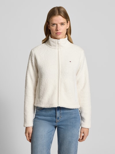 Kobiece modelka nosi Regular Fit Teddy-Jacke mit verdecktem Reißverschluss od Tommy Jeans, imitacja futerka, jednolity kolor, stójka, wyhaftowane logo, długi rękaw, kieszenie na zamek błyskawiczny, wykończenie materiału: futerko, Ganzkörperansicht von vorne.