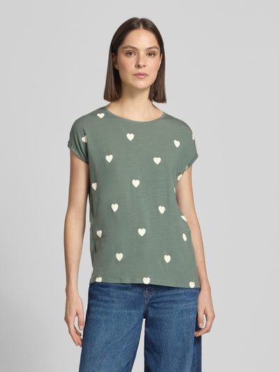 Frauenmodel trägt Relaxed Fit T-Shirt aus Lyocell-Mix Modell 'AVA' von Vero Moda mit Allover-Herz-Print, Rundhalsausschnitt, kurzarm, Ganzkörperansicht von vorne.