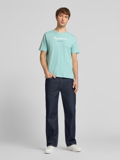 Männermodel trägt Herren T-Shirt von Pepe Jeans, Modell 'EGGO', Optik: Unifarben, Regular-Fit, Label-Print, Rundhals, Kurzarm, Jersey aus reiner Baumwolle, Ganzkörperansicht von vorne.