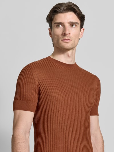 Męski model nosi T-Shirt aus Viskose-Mix in Ripp-Optik von Antony Morato, krój slim fit, okrągły dekolt, rdzawobrązowy, tekstura prążkowana, długość pleców w rozmiarze M: 65 cm, półzbliżenie górnej części ciała.