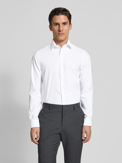 Männermodel trägt wit slim fit business-hemd met kentkraag van CK Calvin Klein, mix van katoen en elastaan, structuurpatroon, gestikt logo, doorlopende knoopsluiting, ruglengte maat 40: 78 cm, schouderbreedte: 44 cm, mouwlengte: 68 cm. Ganzkörperansicht van voren.