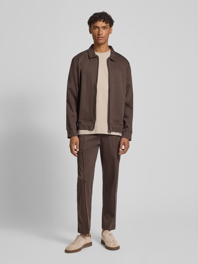 Männermodel trägt Sweatjacke mit Logo-Stitching Modell 'Ricardio' von JOOP! Collection in Braun, Baumwolle, gerader Schnitt, Ganzkörperansicht von vorne.