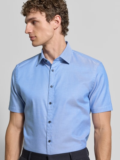 Männermodel trägt Slim Fit Business-Hemd aus Baumwolle mit Kentkragen von Jake*s, hellblau, Knopfleiste, Nahaufnahme Oberkörper.