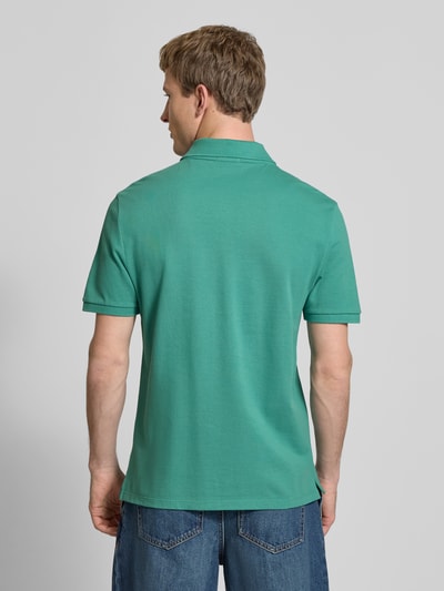 Männermodel trägt Straight Fit Poloshirt mit Label-Stitching von Calvin Klein Jeans in Grün, Reine Baumwolle, Rückenlänge 71 cm, Ganzkörperansicht Rückansicht.