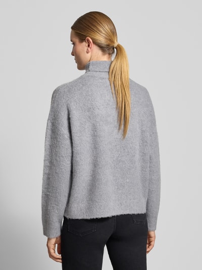 Frauenmodel trägt Regular Fit Pullover mit Leinen-Anteil Modell 'Maglia' von Liu Jo White in Grau, Rollkragen, Rückenansicht, Damen Pullover von Liu Jo White, elastischer Material-Mix mit Leinen-Anteil, Ärmellänge 49 cm, Rückenlänge 58 cm.