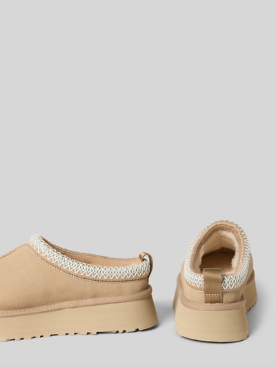 Produktfoto, Hausschuhe mit Label-Detail Modell 'Tazz' von UGG aus beschichtetem Leder-Mix in Beige mit abgerundeter Spitze, strukturierte Sohle, Absatzhöhe 4 cm, Schafthöhe 3 cm, Schaftweite 14 cm.
