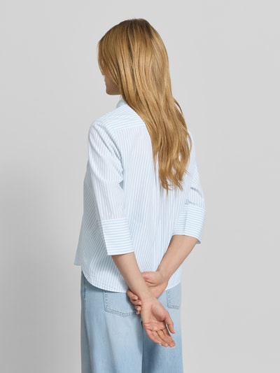 Frauenmodel trägt Regular Fit Hemdbluse aus Lyocell-Baumwoll-Mix von Tom Tailor, hellblau gestreift, Popeline, Ganzkörperansicht Rückansicht.