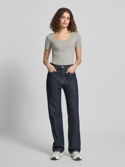Frauenmodel trägt Slim Fit T-Shirt aus Baumwoll-Mix Modell 'KITTE' von Pieces in Optik: Unifarben mit U-Boot-Ausschnitt, Henley, Kurzarm, Ripp-Materialverarbeitung, Ganzkörperansicht von vorne.