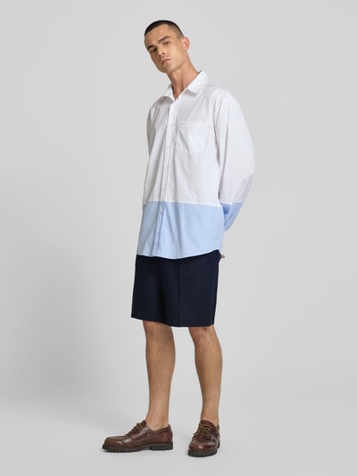 Männermodel trägt Straight Fit Shorts aus Leinen-Mix von Filippa K, dunkelblau, mit Bügelfalten und elastischem Bund, Ganzkörperansicht von vorne.