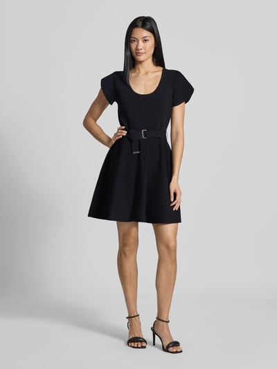 Modelka nosi sukienka mini z mieszanki wiskozy, krój taliowany, pasek w talii, z krótkim rękawem, okrągły dekolt, Model 'Ronella' od Ted Baker, kolor czarny, tekstura gładka, Szerokość w rozmiarze 36: 42 cm, długość tyłu w rozmiarze 36: 84 cm, długość rękawów w rozmiarze 36: 16 cm, widok całej sylwetki z przodu.