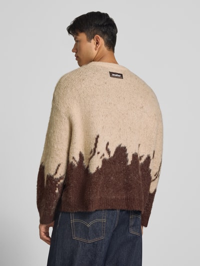 Männermodel trägt Strickpullover mit gerippten Abschlüssen von ANOTHER COTTON LAB, beige-braune Farbverläufe, elastischer Material-Mix, gerade Passform, Rückenansicht, Ganzkörperansicht Rückansicht.