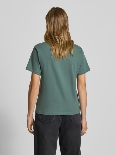 Vrouwenmodel draagt T-shirt met borstzak en label-detail van Carhartt Work In Progress, groene kleur, katoen, regular fit, rugaanzicht.