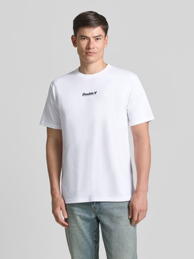 Mannenmodel draagt heren T-shirt van puur katoen, regular fit, model 'Ace' met logoprint en ronde hals van Wood Wood, ruglengte maat M 70 cm, voorkant volledige lichaamsopname.