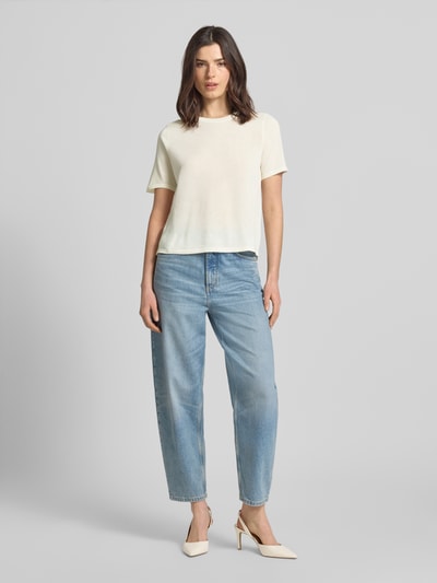 Frauenmodel trägt Damen T-Shirt mit Rundhalsausschnitt Modell 'TENCYM' von Mango, cremefarben, Material-Mix mit Lyocell-Anteil, Regular-Fit, Rückenlänge 55 cm, Ärmellänge 25 cm, Ganzkörperansicht von vorne.