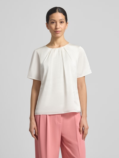 Frauenmodel trägt Regular Fit Bluse mit Rundhalsausschnitt und 1/2-Arm von Christian Berg Woman Selection, cremeweiß, Material-Mix mit Stretch, lockere Passform, strukturierte Oberfläche, Nahaufnahme Oberkörper.