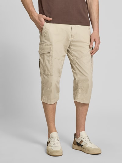 Männermodel trägt Relaxed Fit Cargoshorts aus Baumwoll-Mix von s.Oliver BLACK LABEL in Beige, unifarben, Popeline, Nahaufnahme Oberschenkel.