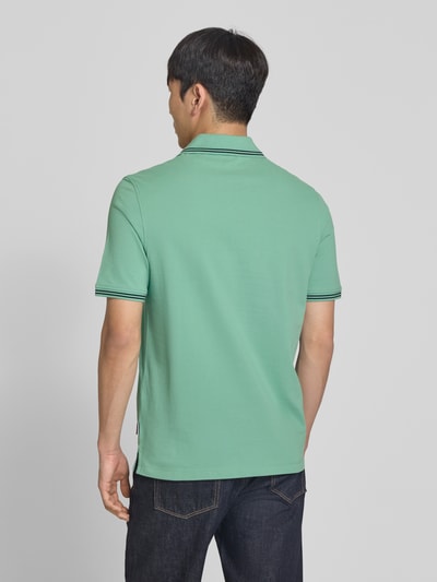 Männermodel trägt Regular Fit Poloshirt mit Logo-Stitching von bugatti in Grün, Reine Baumwolle, Polokragen, Rückenlänge 71 cm, Ganzkörperansicht Rückansicht.