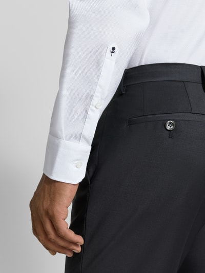 Männermodel trägt Regular Fit Business Hemd mit Kentkragen aus reiner Baumwolle von Seidensticker, Nahaufnahme seitlicher Oberkörper, feine Struktur und glatte Knopfleiste, dunkle Hose, Kontext: Rückenlänge 72 cm, Schulterbreite 48 cm, Ärmellänge 67 cm.