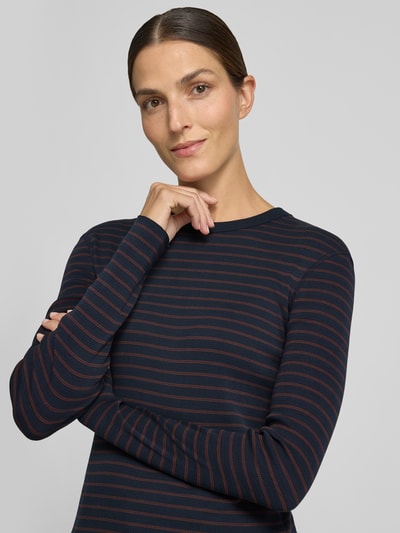 Frauenmodel trägt Slim Fit Longsleeve aus reiner Baumwolle Modell 'NURIT' von DRYKORN, dunkelblau mit roten Streifen, Nahaufnahme Oberkörper.