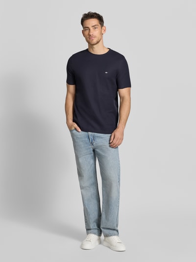 Mannenmodel draagt Regular Fit T-shirt met gestikt logo van Fynch-Hatton, puur katoen, ronde hals, ruglengte maat M 68 cm. Ganzlichaamsaanzicht van voren.