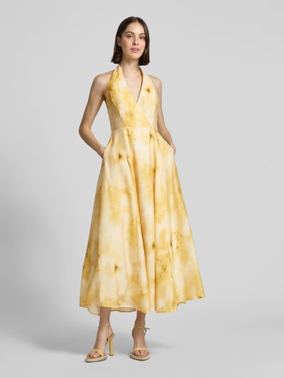 Modelka kobieca nosi Midikleid aus Lyocell-Mix mit Eingrifftaschen Modell 'FIE' od Copenhagen Muse, żółte odcienie, A-linia, V-dekolt, długość tyłu w rozmiarze S: 11 cm, szerokość w rozmiarze S: 40 cm, całkowity widok z przodu.