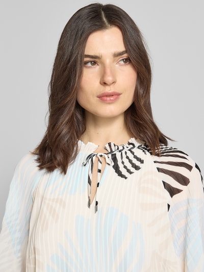 Modelka kobieca nosi Regular Fit Blusenshirt in Plissee-Optik od s.Oliver BLACK LABEL, motyw allover/unikolor, krój regular fit, kołnierz z falbanką, plisowania, dekolt okrągły z rozcięciem i wiązaniem, krótki rękaw, przód z bliska