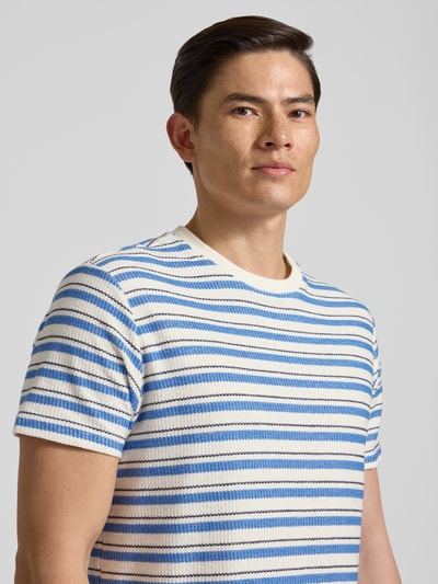 Männermodel trägt T-Shirt mit Streifenmuster Modell 'MARINA' von Guess, reine Baumwolle, Regular Fit, Rundhalsausschnitt, Nahaufnahme Oberkörper.