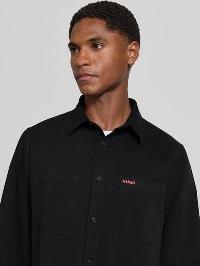 Männermodel trägt schwarze Straight Fit Hemdjacke aus Baumwolle Modell 'Egrin' von HUGO, Herren Hemdjacke, Nahaufnahme Oberkörper.