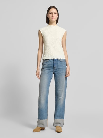 Vrouwenmodel draagt Top mit Strukturmuster van Jake*s Collection, katoenmix met stretch, regular fit, opstaande kraag, ruglengte maat S 53 cm, structuurpatroon in ecru, rechte jeans, lichte achtergrond, full body voorkant.